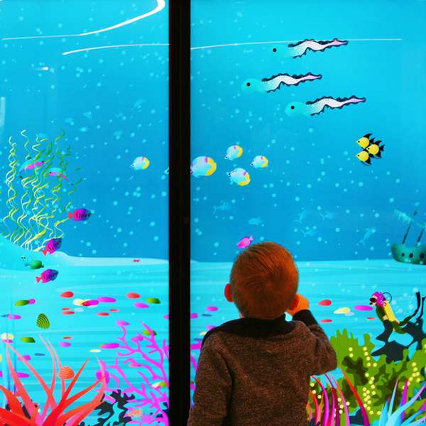 A child looking at the interactive on a wall tablet